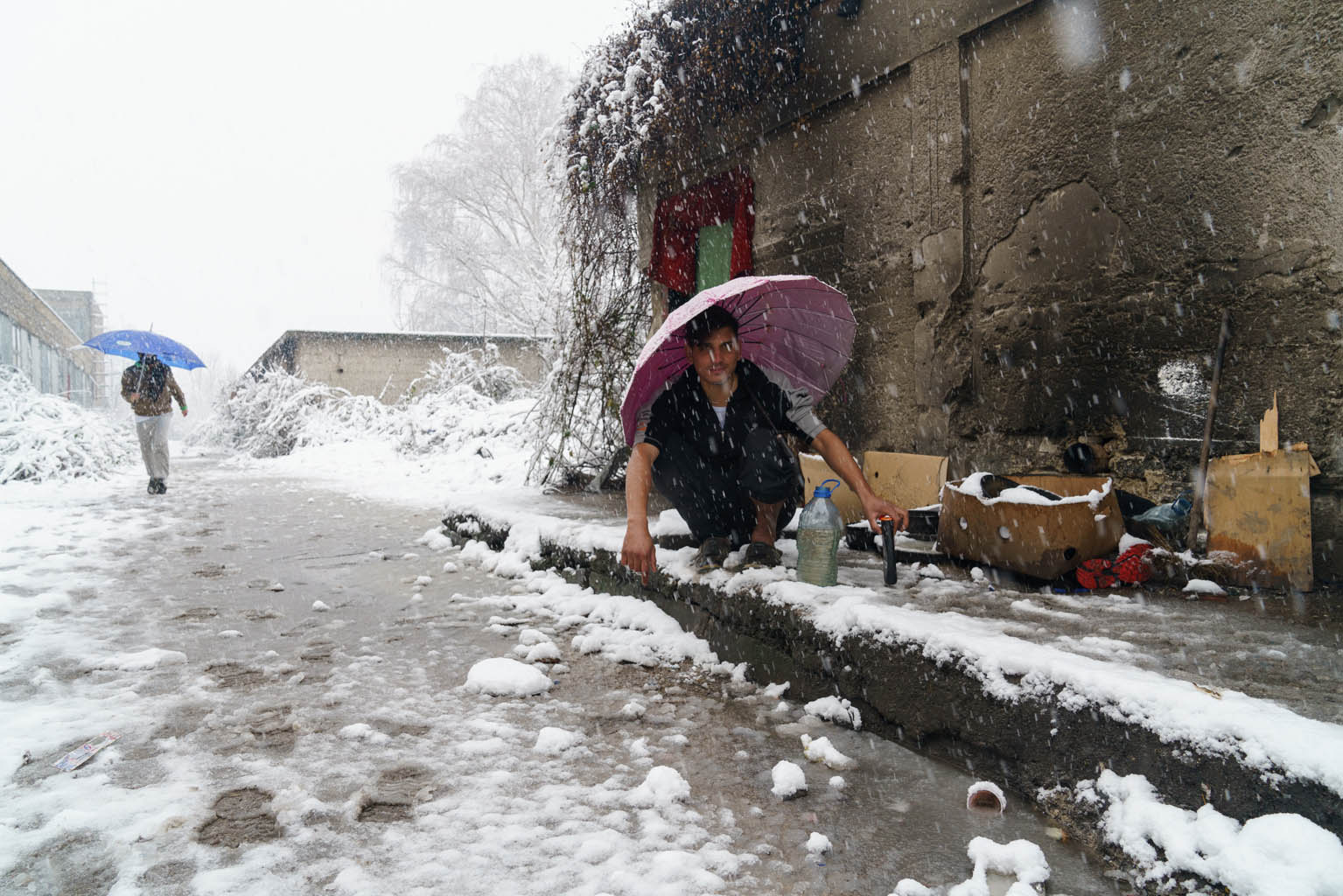 Al Krajina Metal di Bihac, migrante intento a lavarsi sotto la neve
